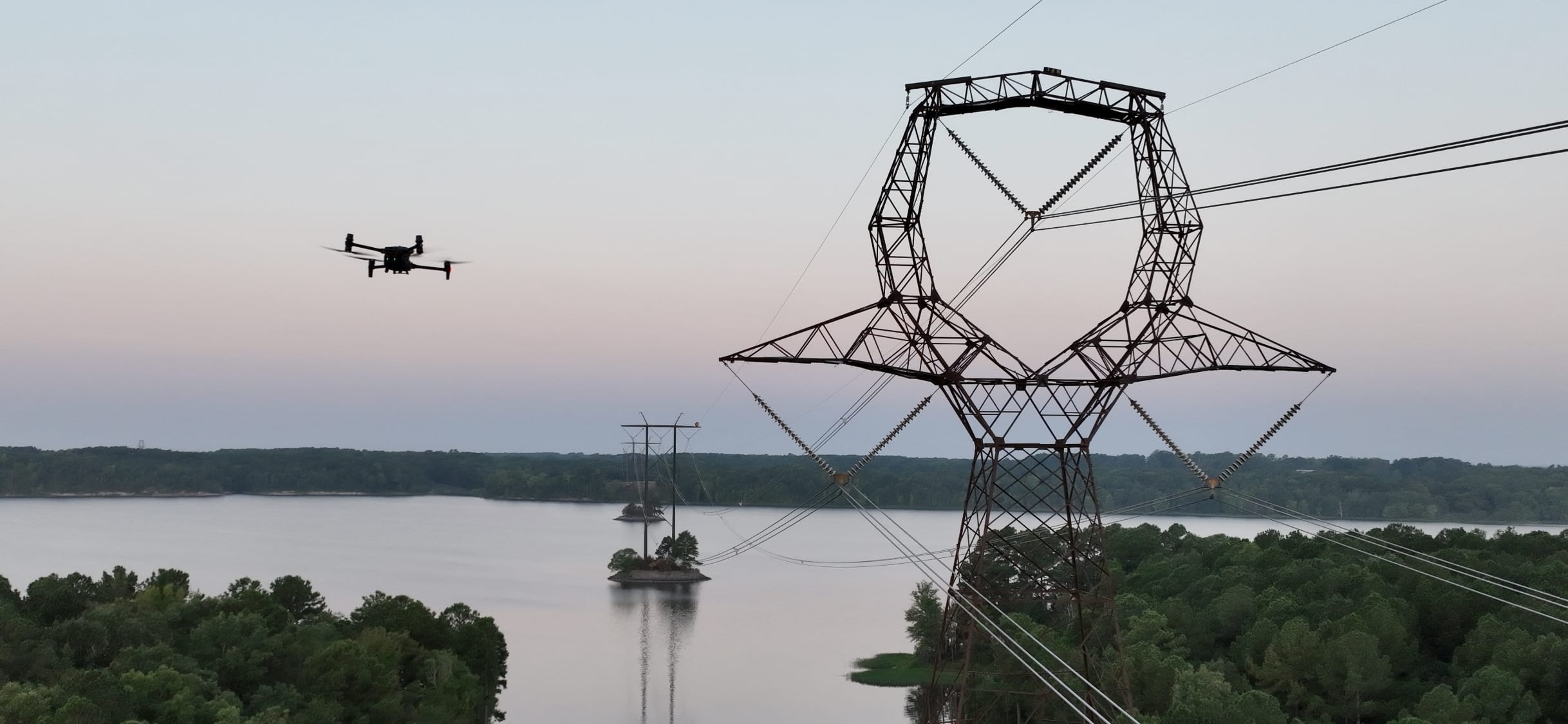 drone flying over river and around powerlines